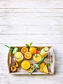 Gelbe Smoothies mit Mango, Orangen, Ananas und Ingwer