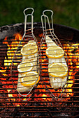 Zander fillets in fish baskets on a grill