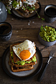 Waffles with avocado, bacon, fried egg and maple syrup