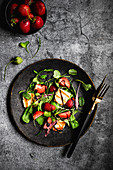 Salad with halloumi strawberries arugula radish leaves and balsamic sauce
