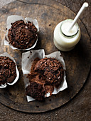 Chocolate muffins with milk on brown backgroundtop view