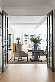 View through open transom door into living room with baluster table