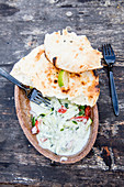 Herb salad with cucumber and bell pepper served with naan bread