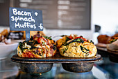 Savoury muffins with bacon and spinach on a restaurant counter