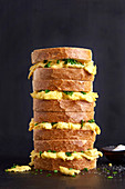 Piled up sandwiches made of white bread with scrambled eggs and chives