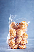 Coconut macaroons in a cellophane bag against a blue background