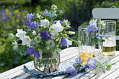 Blau-weißer Strauß aus Glockenblumen und Jungfer im Grünen, dekoriert mit Holz-Herzen, Bierkrüge