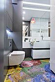 Mosaic floor tiles with pixelated floral motif in modern bathroom