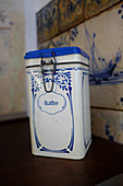 Old blue-and-white coffee can in front of old tiles