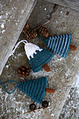 Knitted winter decorations in shapes of fir trees on rustic wood