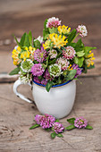A bouquet of various types of clover in a jug