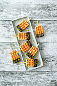Waffles on a stick in chocolate with pistachios