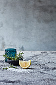 Still life with rosemary and a lemon wedge