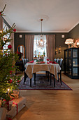 Festively set table in classic dining room decorated for Christmas