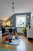 Christmas tree in child's bedroom with blue walls and sloping ceiling
