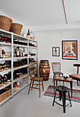 Various old chairs next to shelves holding bottles of spirits and wines