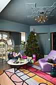 Christmas tree in colourful living room with blue walls