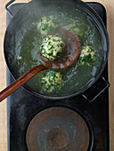 Spinach semolina dumplings in a saucepan
