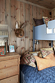 Bunk beds in rustic children's bedroom with wood-clad walls