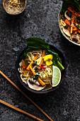 Noodle soup with carrots, mushrooms, pak choi and sesame seeds (Asia)