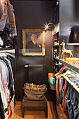 Gilt-framed portrait on dark grey wall of walk-in wardrobe
