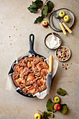 Apple hazelnut skillet cake with a knife and serving plates.