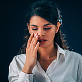 Young woman touching her face