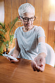 Senior woman doing elbow physical therapy with TENS