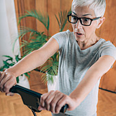 Surprised senior woman measuring weight on digital scale