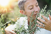 Woman enjoying the scent of rosemary