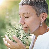 Woman enjoying the scent of rosemary