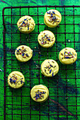 Cookies with a glaze and edible flowers on a cooling rack
