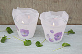 Candle lanterns decorated with parchment paper and pressed violas