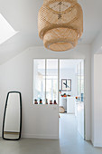 White walls and bamboo lightshade in hallway