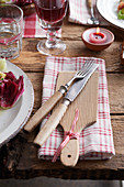 Stoffserviette mit Holzbrettchen und Besteck auf rustikalem Tisch