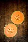 Halbierte Cantaloupe-Melone auf Holzuntergrund