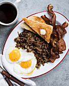 Englisches Frühstück mit Spiegeleiern, Zwiebeln und Speck