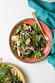 Baby spinach, red onion, date and almond salad with pieces of toasted flatbread.