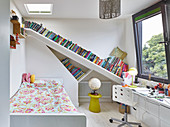 Slanted bookshelves in child's bedroom decorated in white