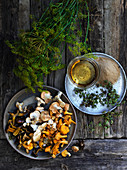 Freshly picked wild mushrooms with herbs on a wooden table