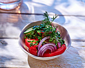 Tomato salad with cucumber, onion and fresh herbs