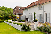 Exterior facade of converted barn with shutters and gravel terrace