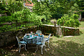 Circular table and chairs in garden on riverbank