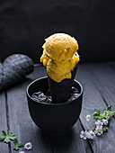 Vegan mango sorbet in a black waffle cone