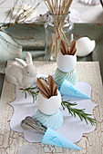 Table decorated in vintage style with folded paper bunny ears in egg shells
