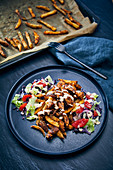 Veganer Seitan-'Kebab-Teller mit Pommes und Harissa-Joghurt-Sauce
