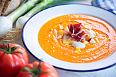 Traditional spanish salmorejo - cold tomato soup served with boiled egg, iberico ham and olive oil