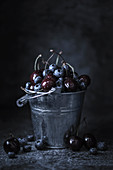 Blueberries and cherries in a zinc bucket