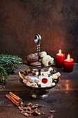 Various Christmas biscuits on a cake stand by candlelight