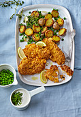 Chicken fillet in cornflakes with potatoes and peas